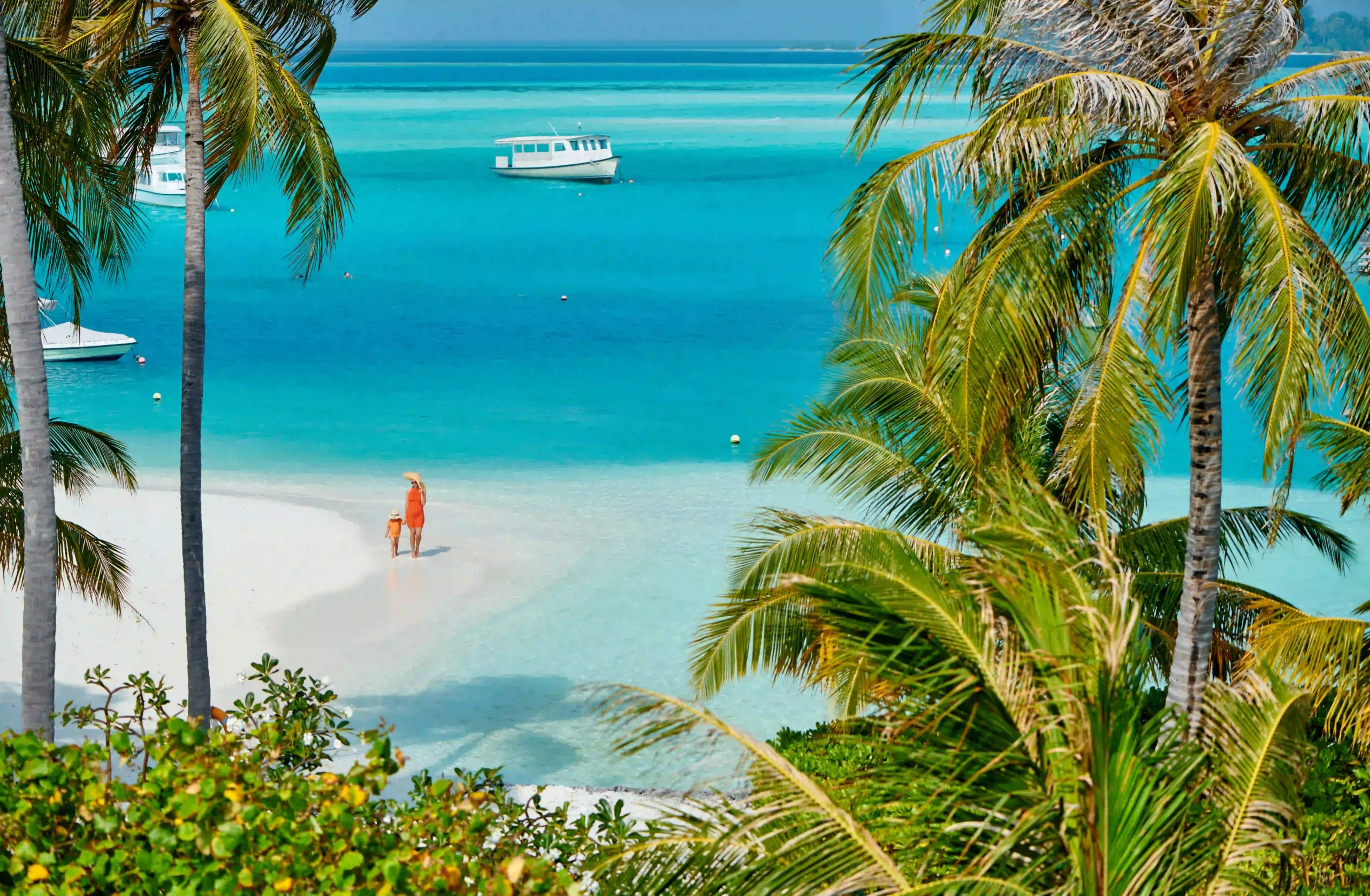 Mother and child on a white sand beach in Zanzibar, starting point for fly in safaris to Serengeti