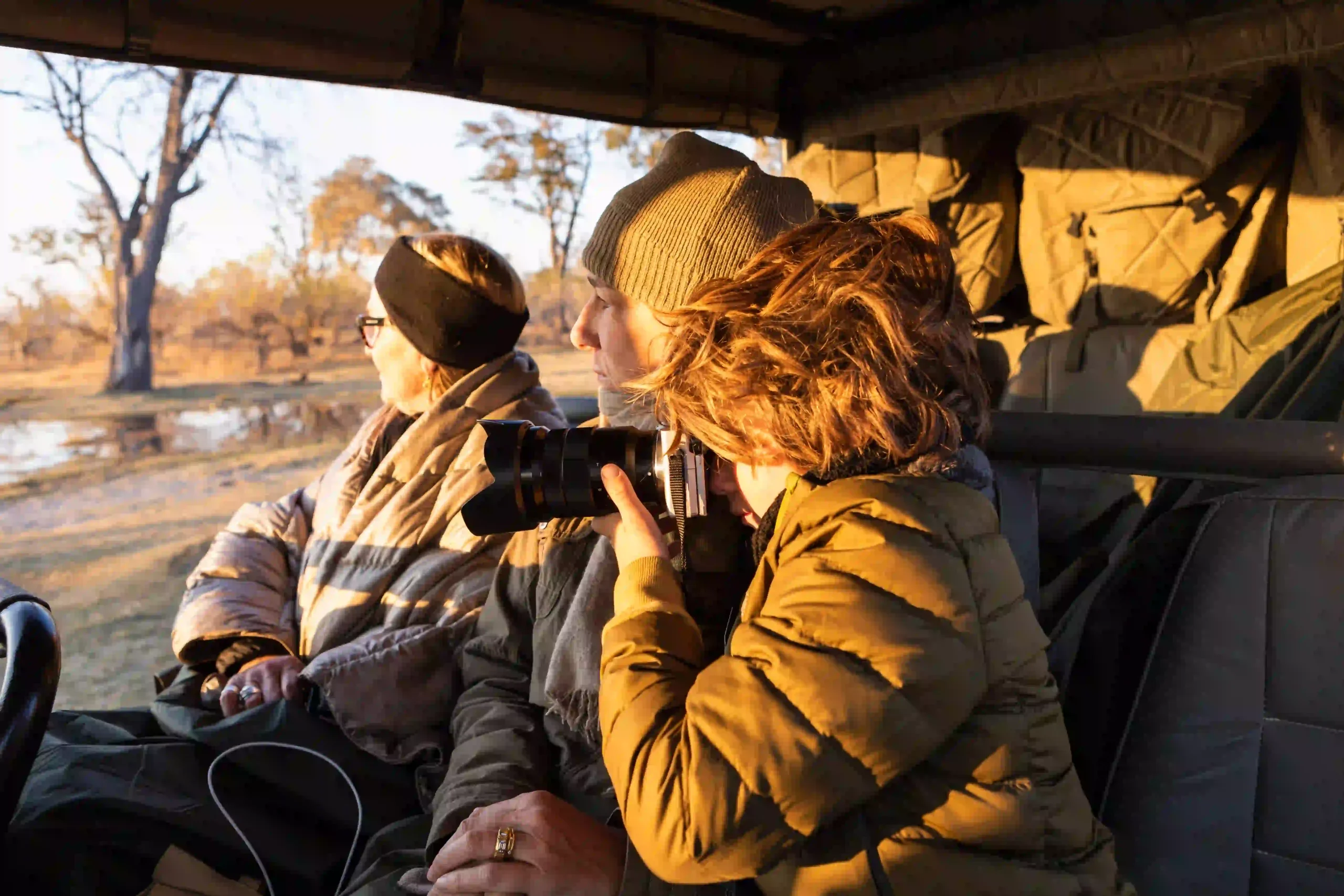 Young traveler photographing wildlife from a safari vehicle